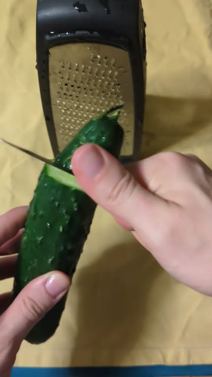 Un cetriolo viene grattugiato sopra un panno